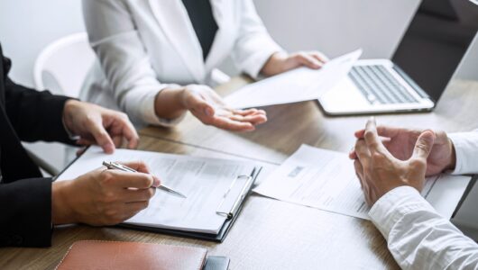 Employer or committee holding reading a resume with talking during about his profile of candidate, employer in suit is conducting a job interview, manager resource employment and recruitment concept.